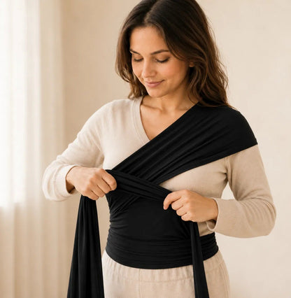 Femme nouant l'écharpe de portage extensible NEVA autour d'elle