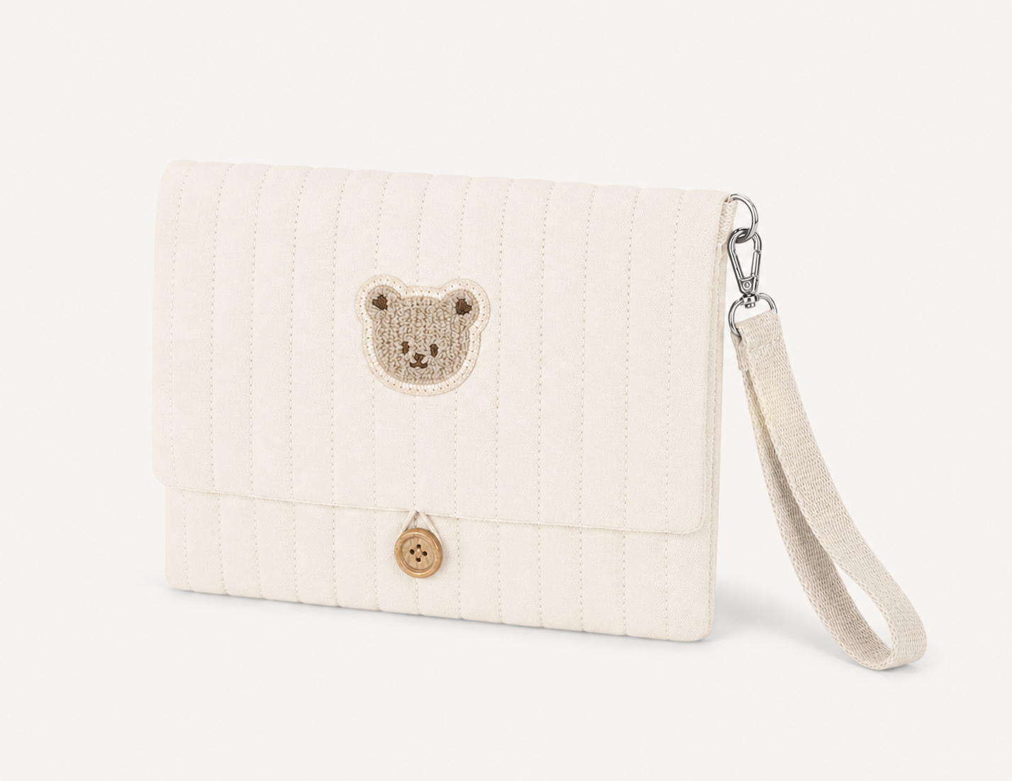 Pochette à langer NEVA Paris ivoire en coton matelassé, patch ourson brodé et dragonne détachable, fond blanc