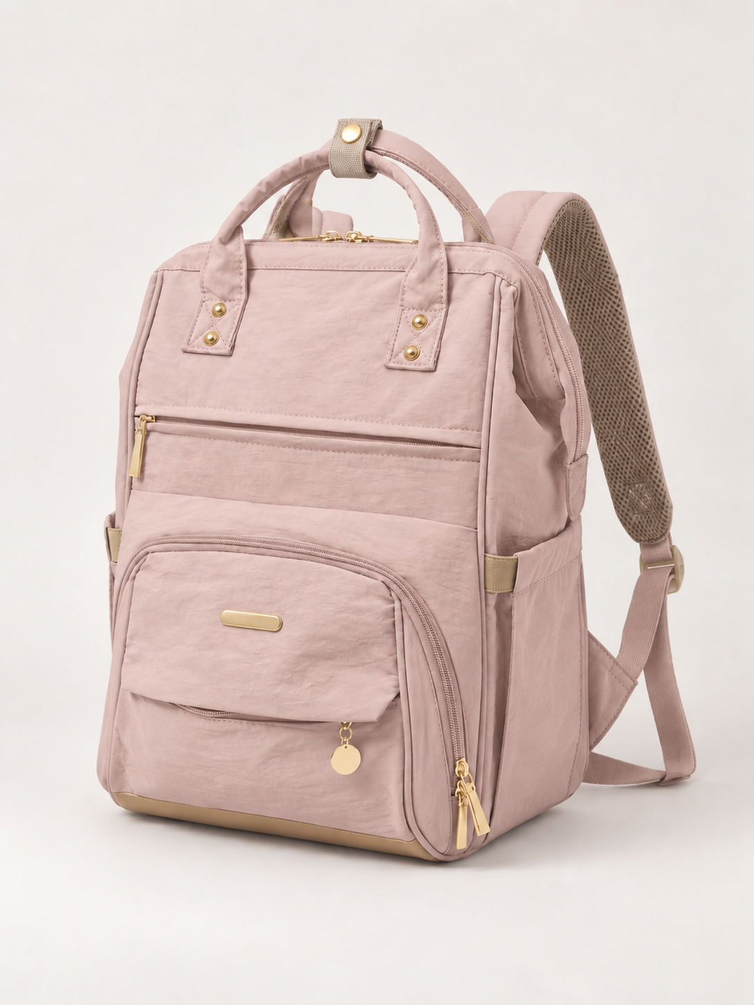 Sac à langer NEVA L'Essentiel rose poudré, vue de trois quarts, détails beige et quincaillerie dorée.